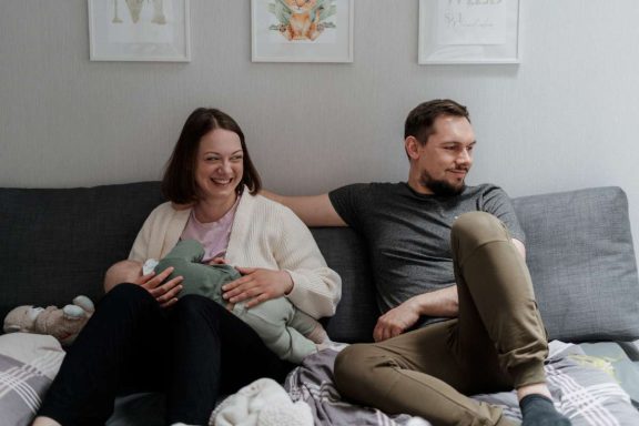 Pärchen auf der Couch mit Baby