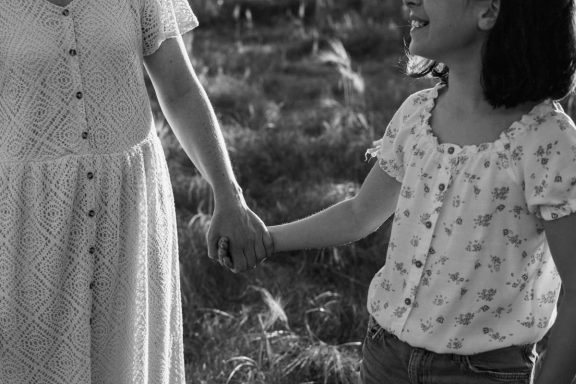 Mutter und Kind spazieren Hand in Hand